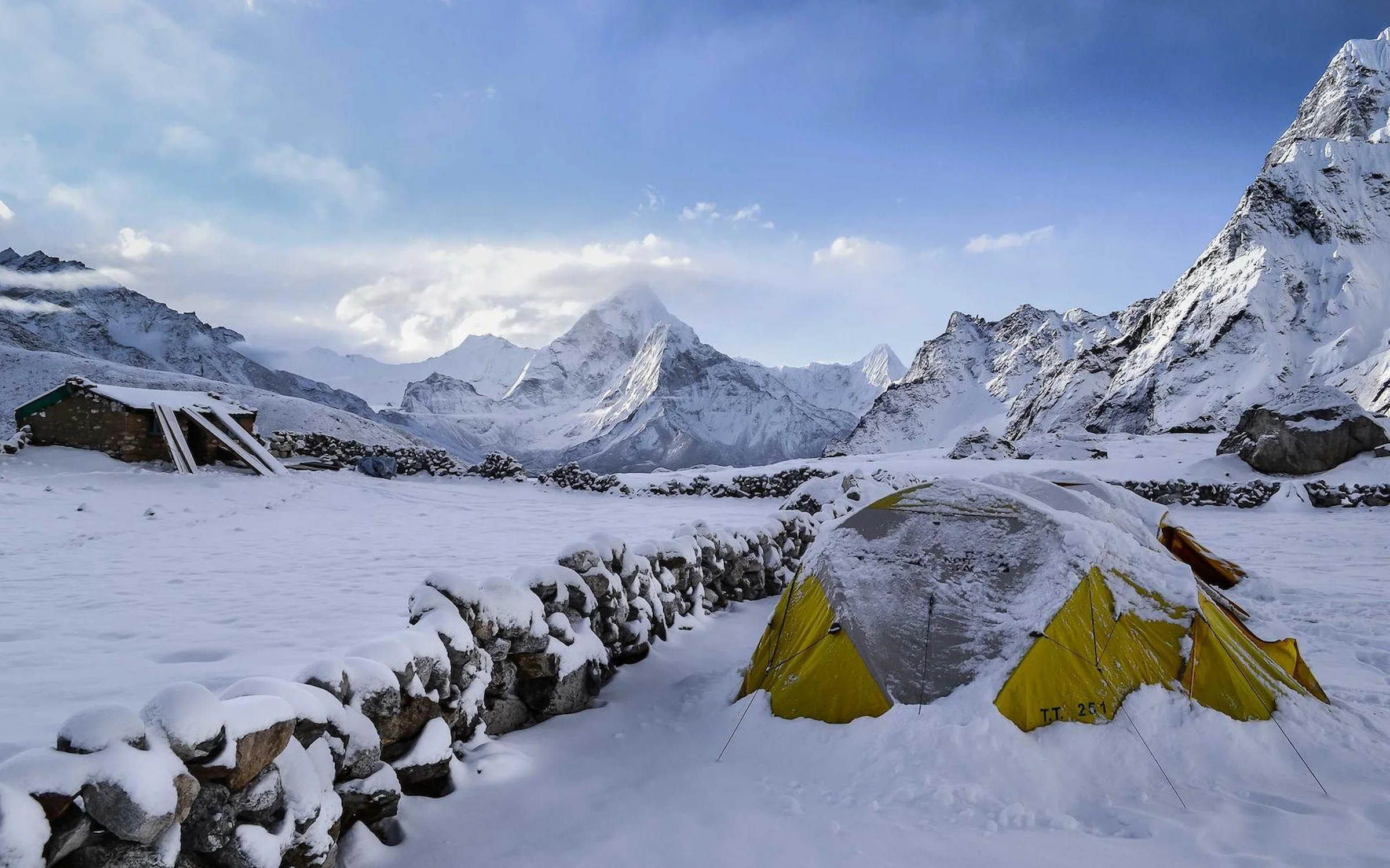 Tente jaune au camp de base, sous les sommets enneigés de l'Himalaya