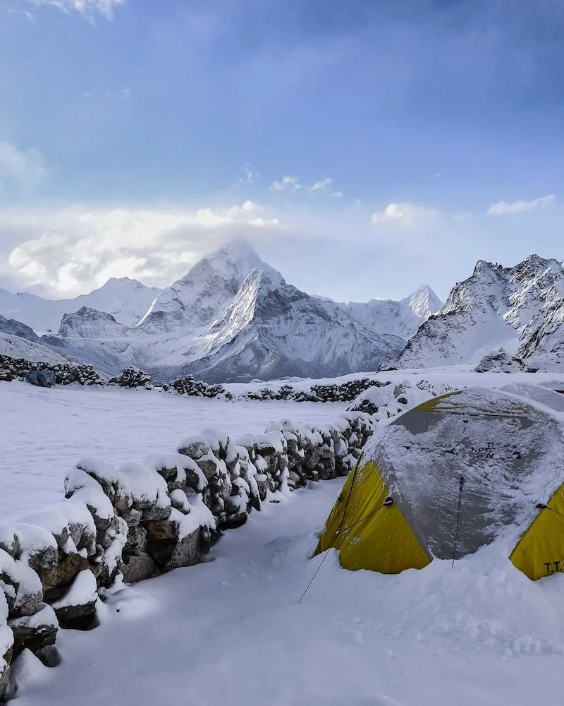 Tente jaune au camp de base, sous les sommets enneigés de l'Himalaya
