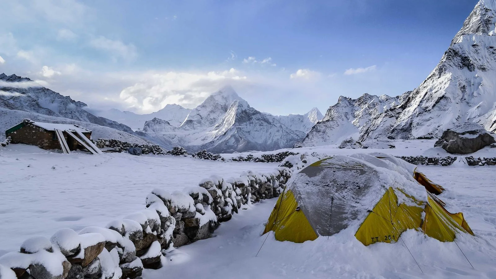 Tente jaune au camp de base, sous les sommets enneigés de l'Himalaya