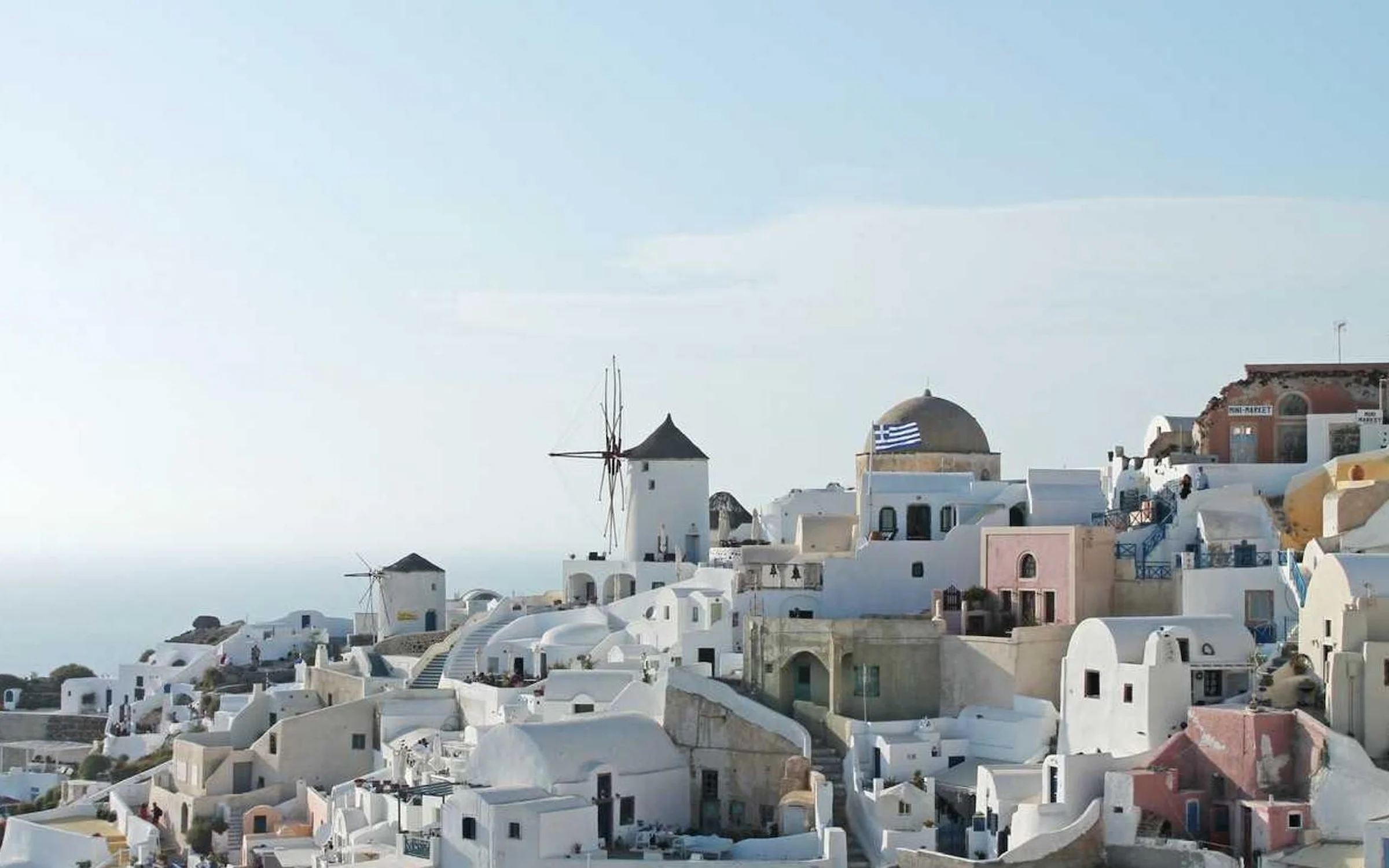 Maisons blanchies à la chaux, coupole bleue et moulins à vent d'Oia, sur l'île de Santorin