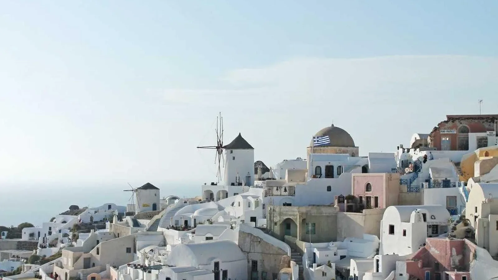Maisons blanchies à la chaux, coupole bleue et moulins à vent d'Oia, sur l'île de Santorin