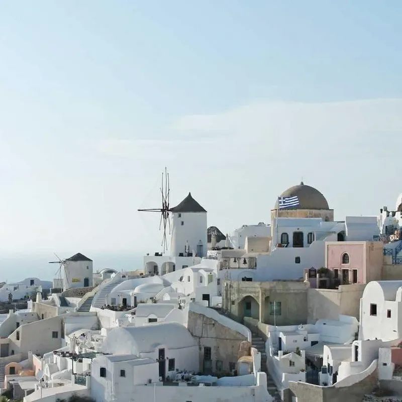 Maisons blanchies à la chaux, coupole bleue et moulins à vent d'Oia, sur l'île de Santorin