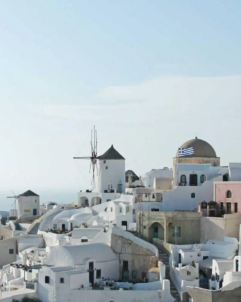 Maisons blanchies à la chaux, coupole bleue et moulins à vent d'Oia, sur l'île de Santorin
