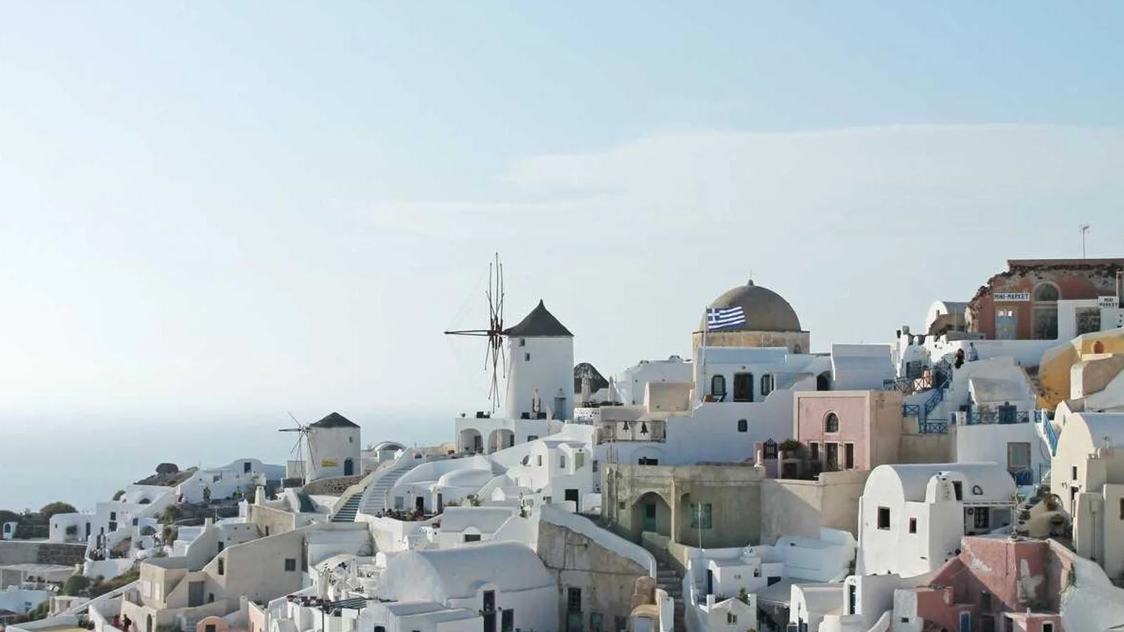 Maisons blanchies à la chaux, coupole bleue et moulins à vent d'Oia, sur l'île de Santorin