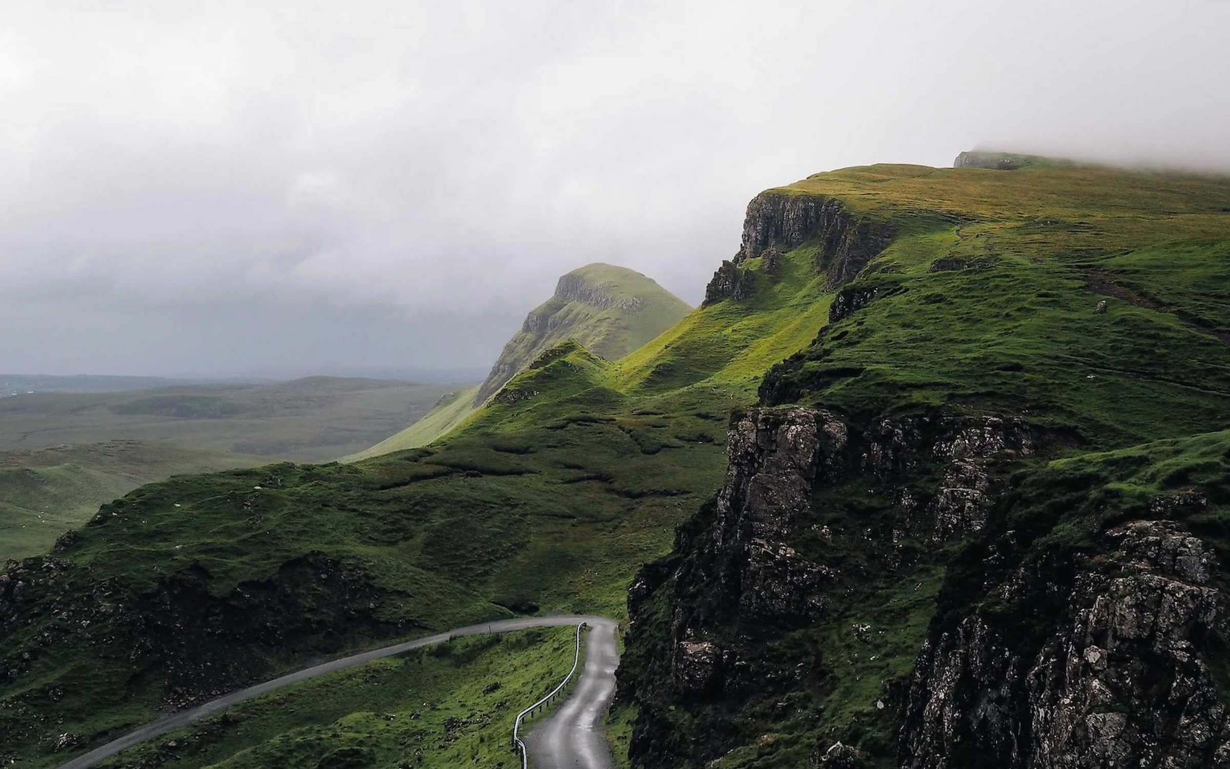 Route sinueuse au pied des falaises du Quiraing, île de Skye