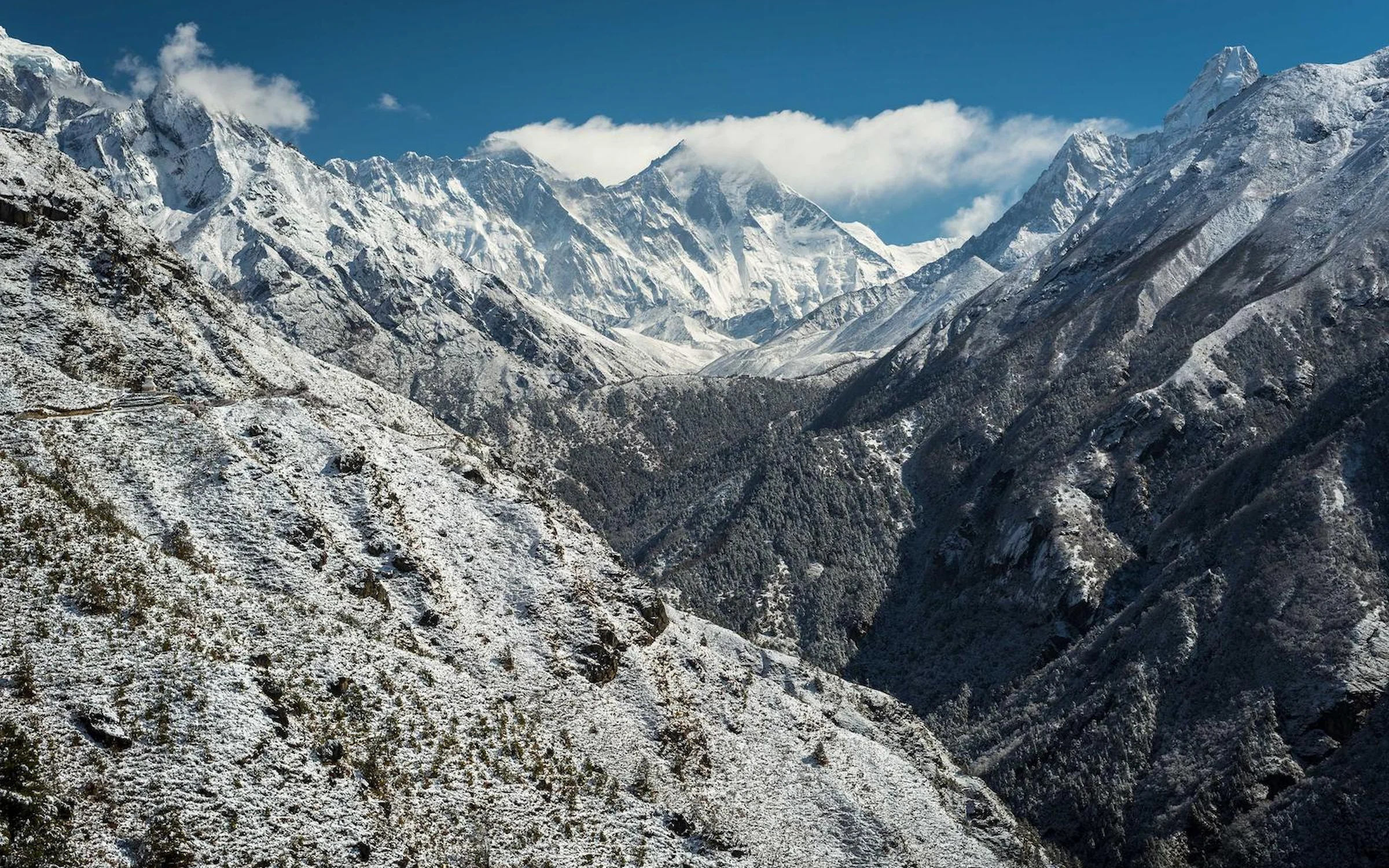 Vallée encaissée et versants saupoudrés de neige sous les sommets de la région de l'Everest